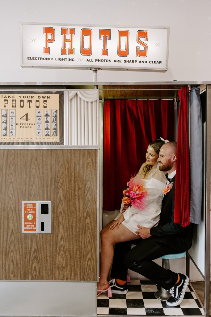 bride and groom sit in photobooth before heading to Downtown Tattoo shop