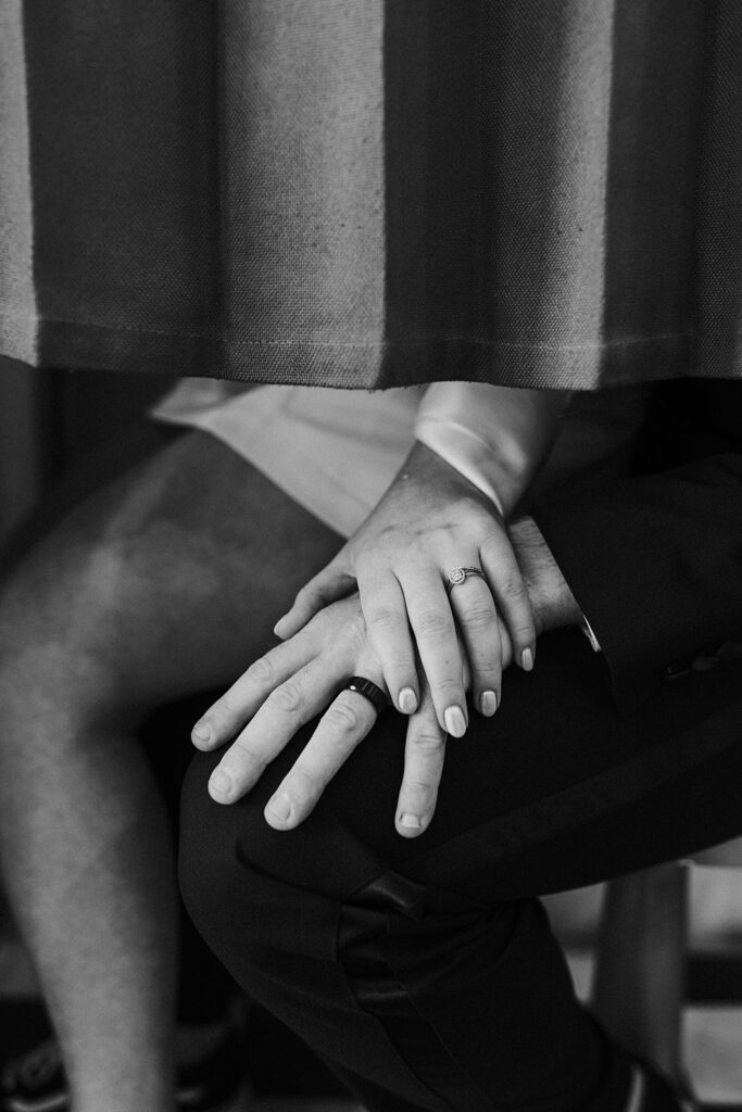 woman's hand placed on top of man's to show off rings by Las Vegas elopement photographer