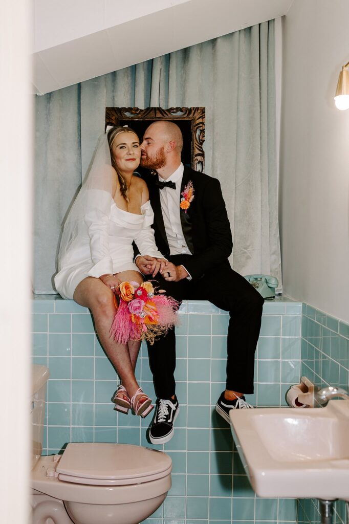 man kisses woman's cheek in bathroom by Las Vegas elopement photographer