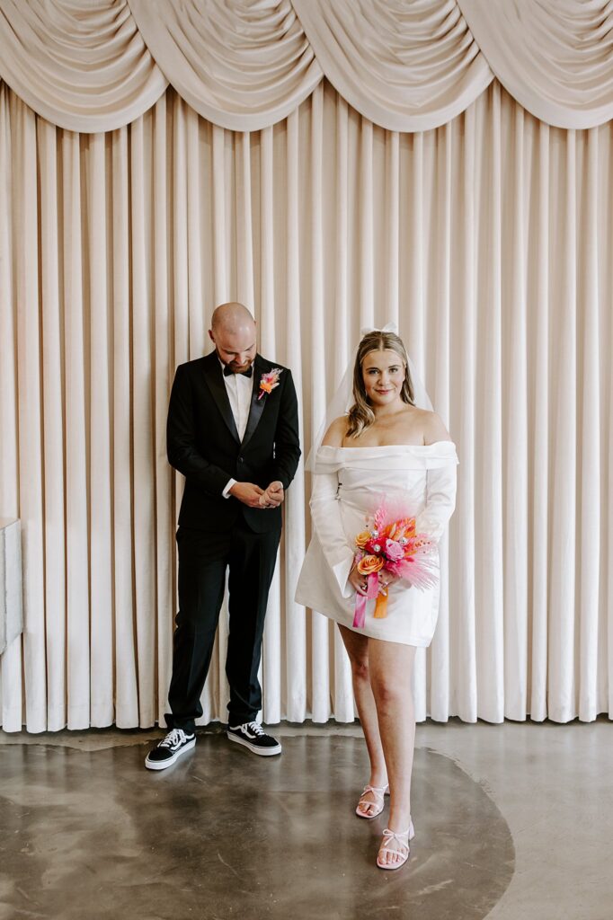 groom adjusts cufflinks as bride smiles before going to Downtown Tattoo shop