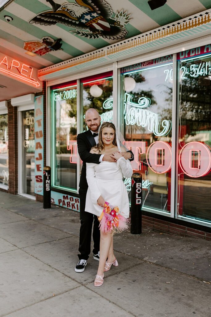 man warps arms around woman's shoulders from behind by Las Vegas elopement photographer