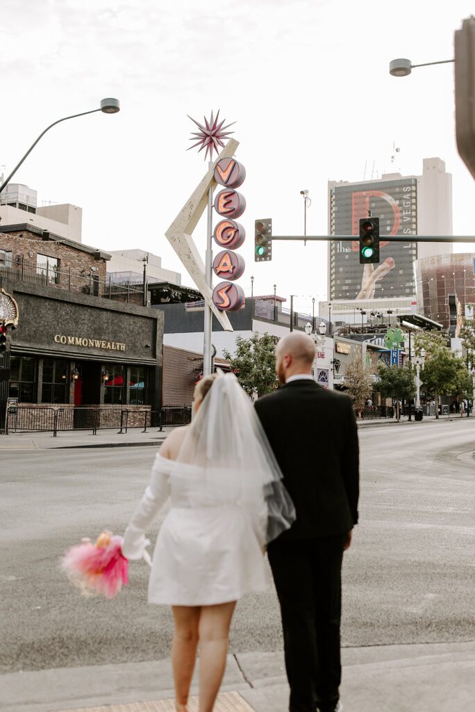 bride and groom hold hands walking away from Downtown Tattoo shop