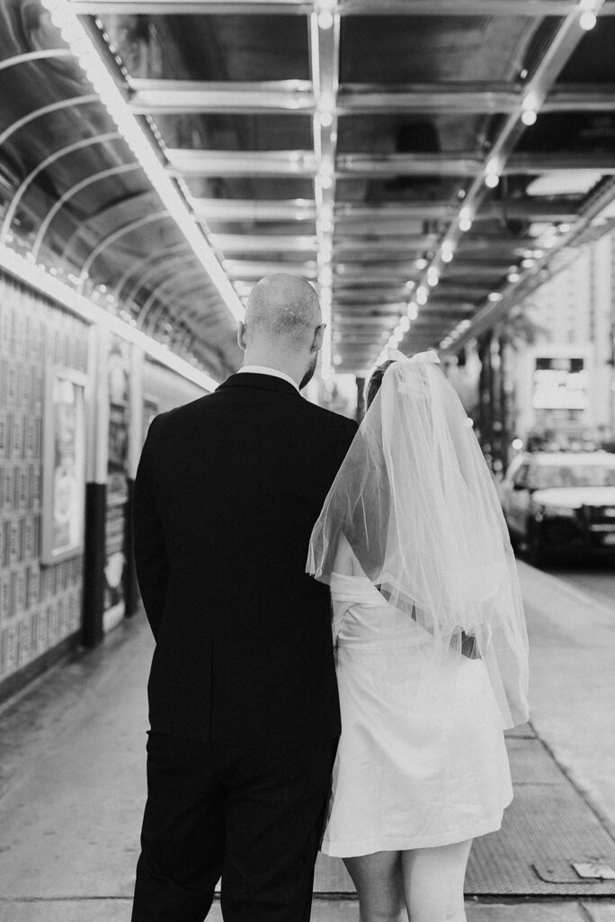 newlyweds walk down Fremont Street after visiting Downtown Tattoo shop