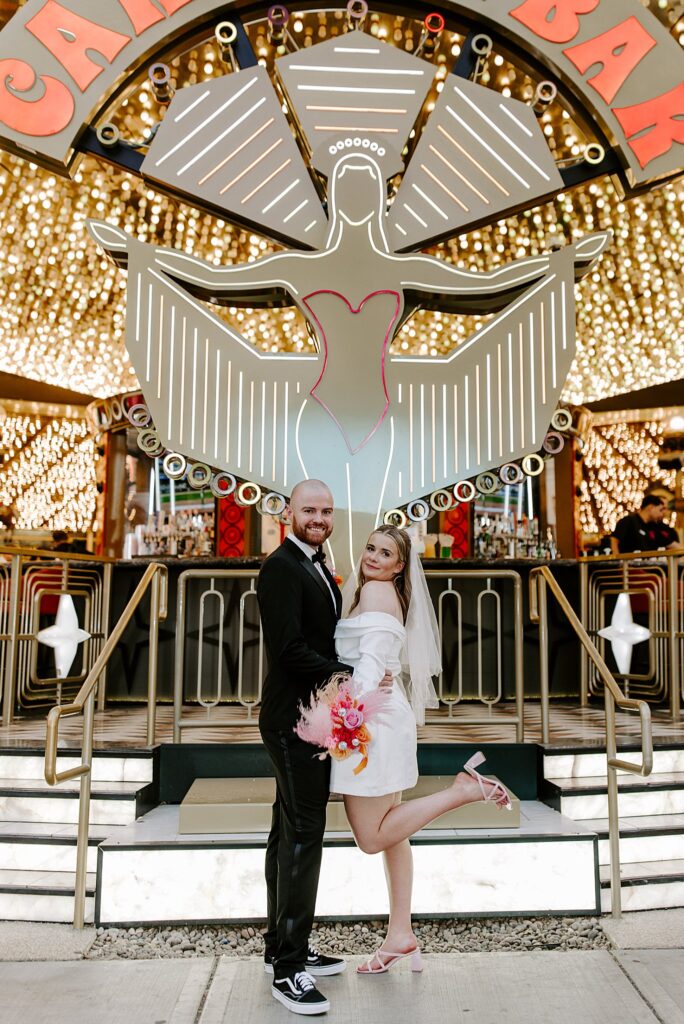 bride kicks out leg under bright lights by Katelyn Faye Photography