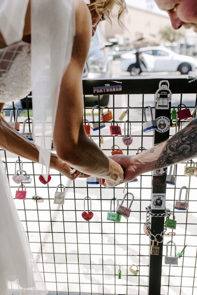 couple places lock on fence before ceremony by Las Vegas Wedding photographer