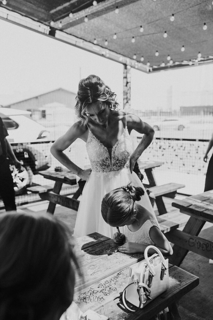 bride watches girl write on table by Katelyn Faye Photography 