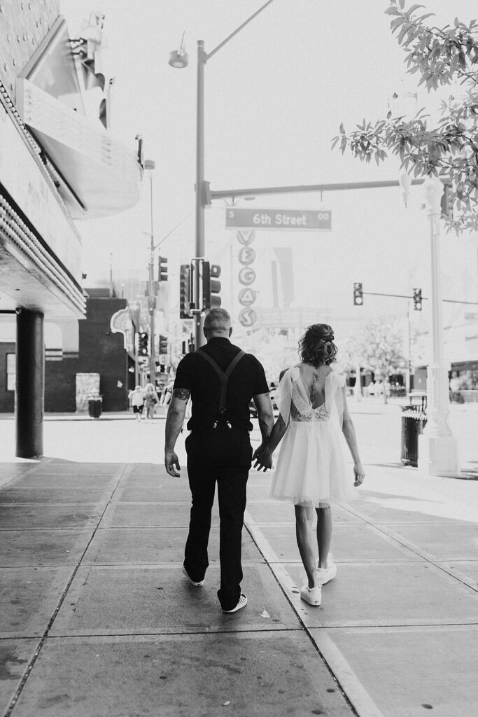 couple walks hand in hand along the strip by Las Vegas Wedding photographer