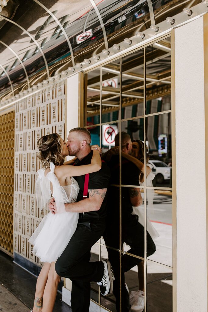 after ceremony at the Punk Rock Museum, couple kisses on Fremont street