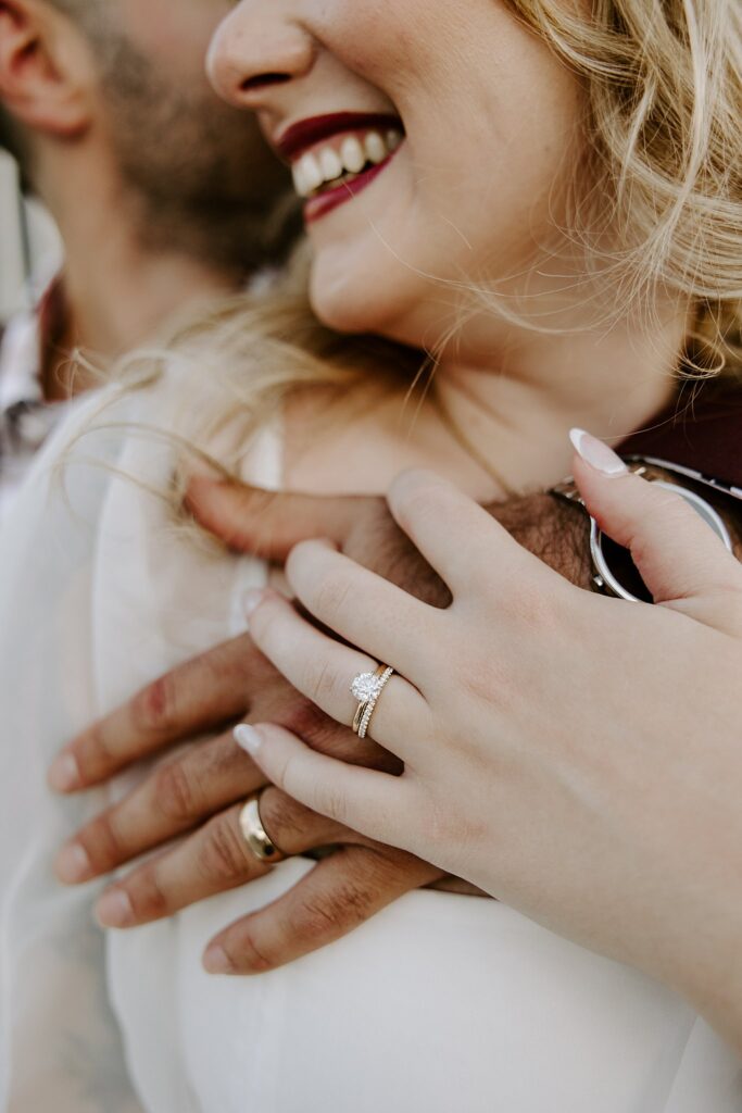 woman shows off new wedding ring as she holds onto groom's hand by Katelyn Faye Photography