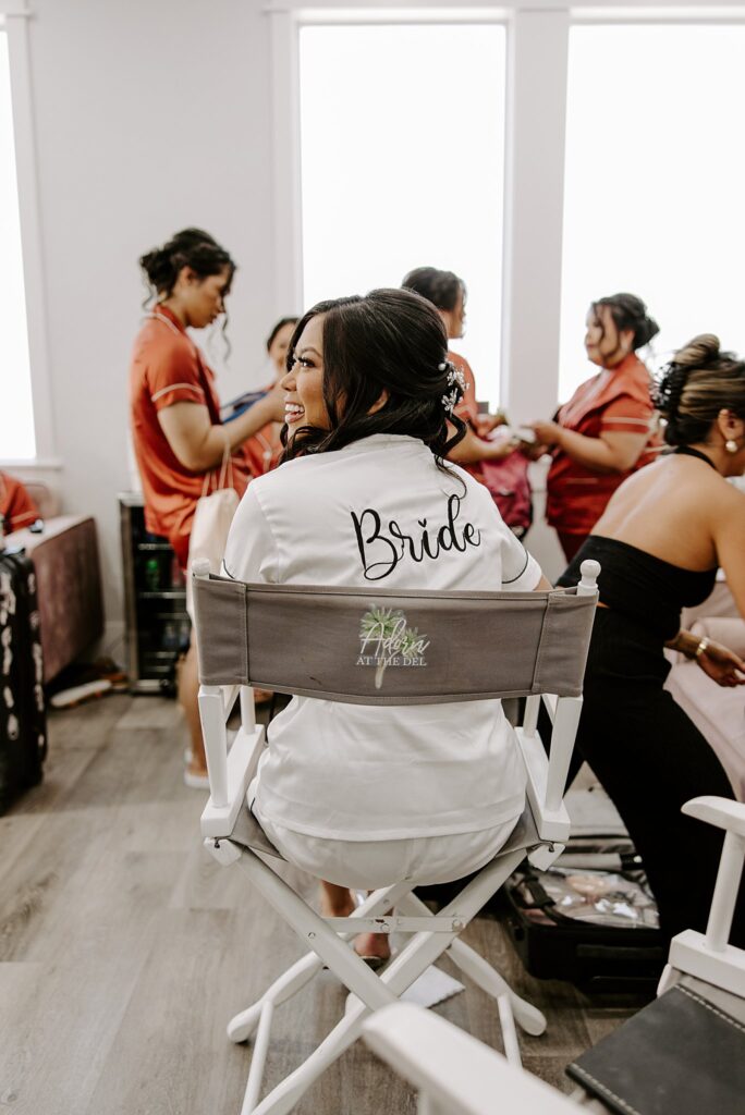 bride looks behind her as she gets ready by Las Vegas wedding photographer