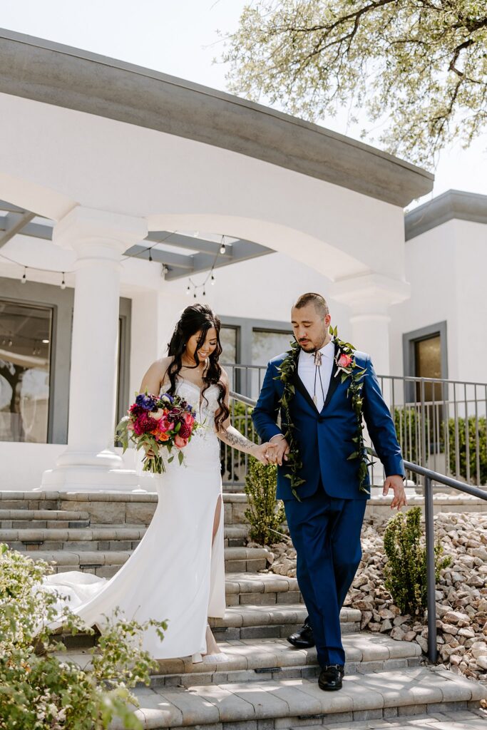 groom helps bride walk down steps by Katelyn Faye Photography