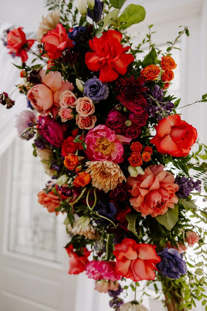 bright wedding floral arrangement hangs by Katelyn Faye Photography