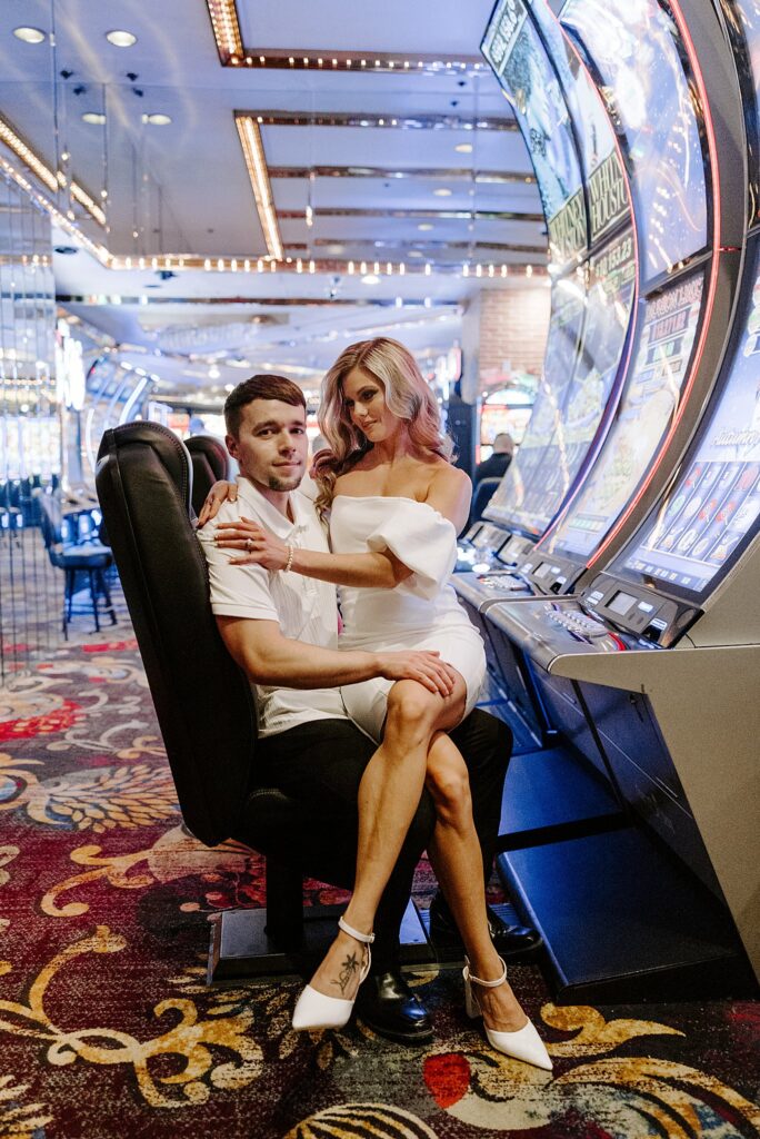 woman sits in man's lap at slot machine at Fremont Street engagement session 