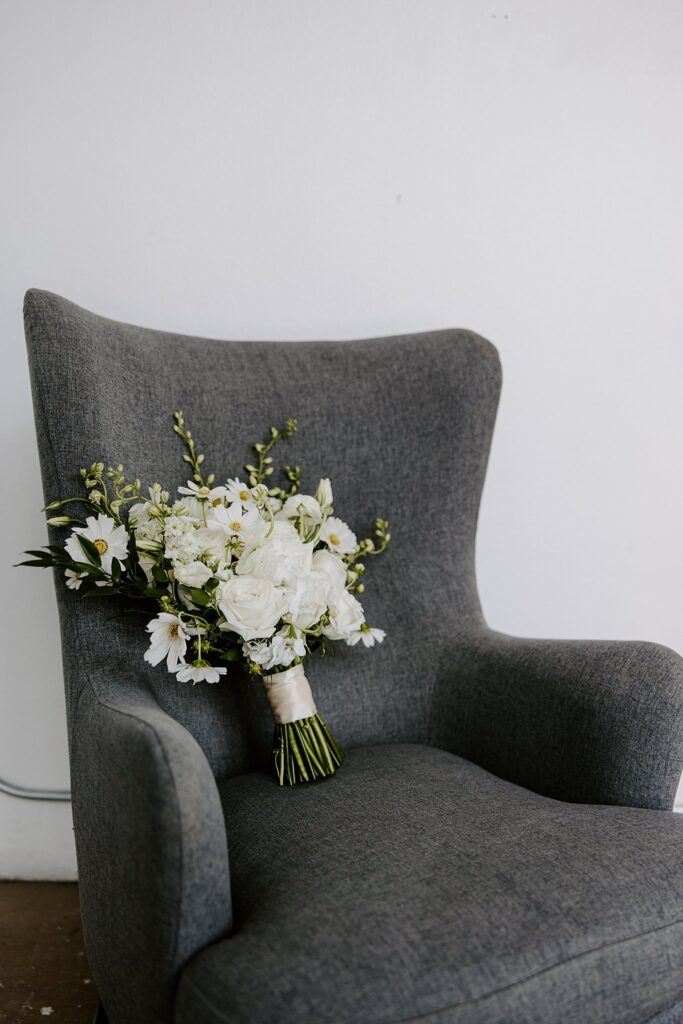 bridal bouquet sits on gray chair by Las Vegas Wedding Photographer