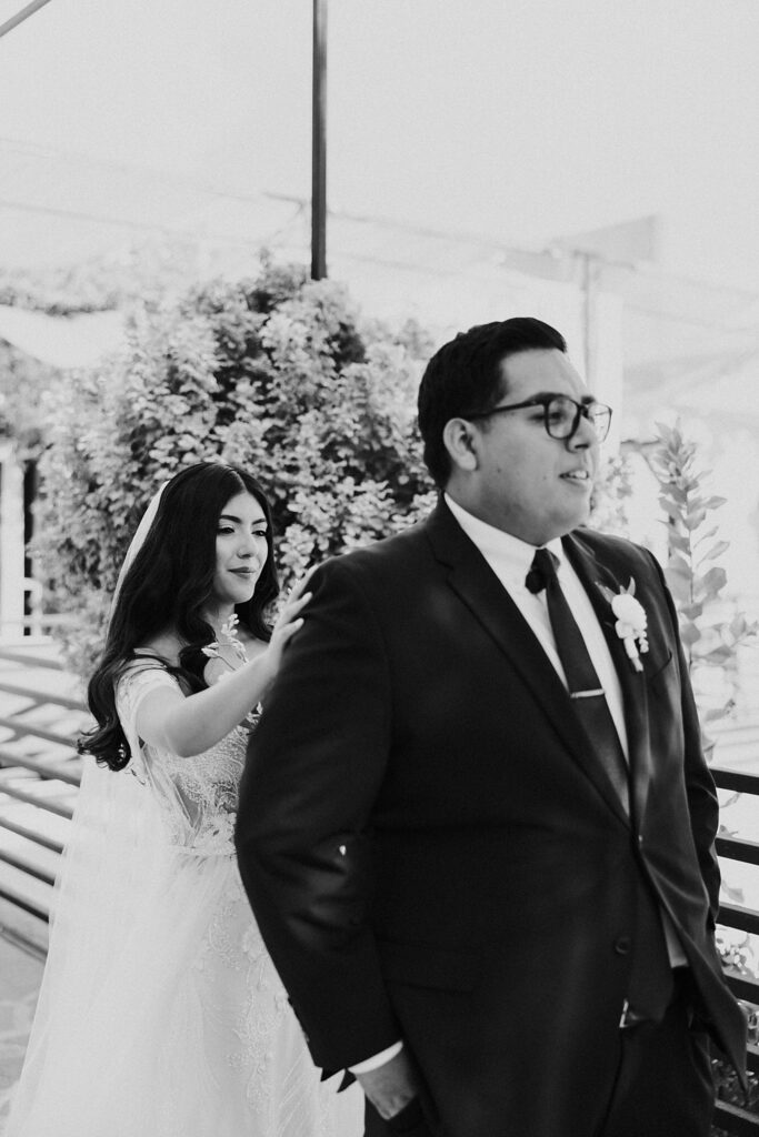 bride taps groom on shoulder during first look by Katelyn Faye Photography