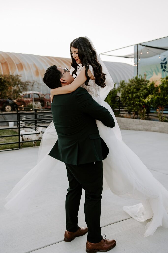 groom picks up bride outside at The Doyle