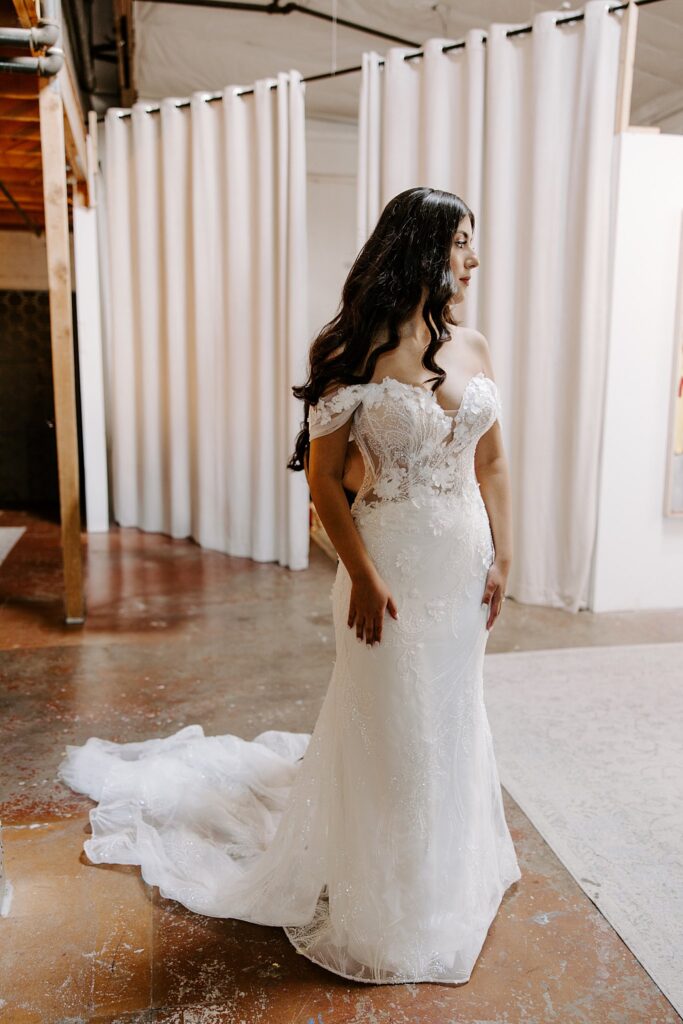 woman in wedding gown looks over her shoulder by Katelyn Faye Photography