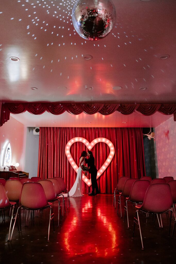 disco ball lights up ceiling as newlyweds kiss by Las Vegas wedding photographer