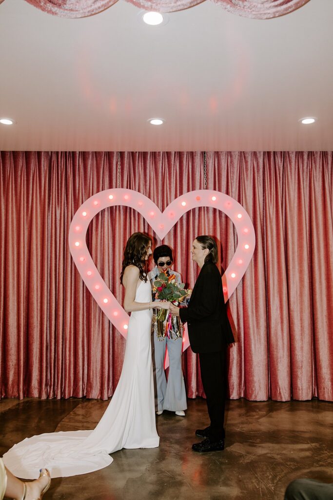 couple holds hands at altar as they exchange vows by Katelyn Faye Photography