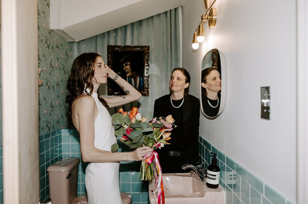 woman watches bride fix her hair by Las Vegas elopement photographer