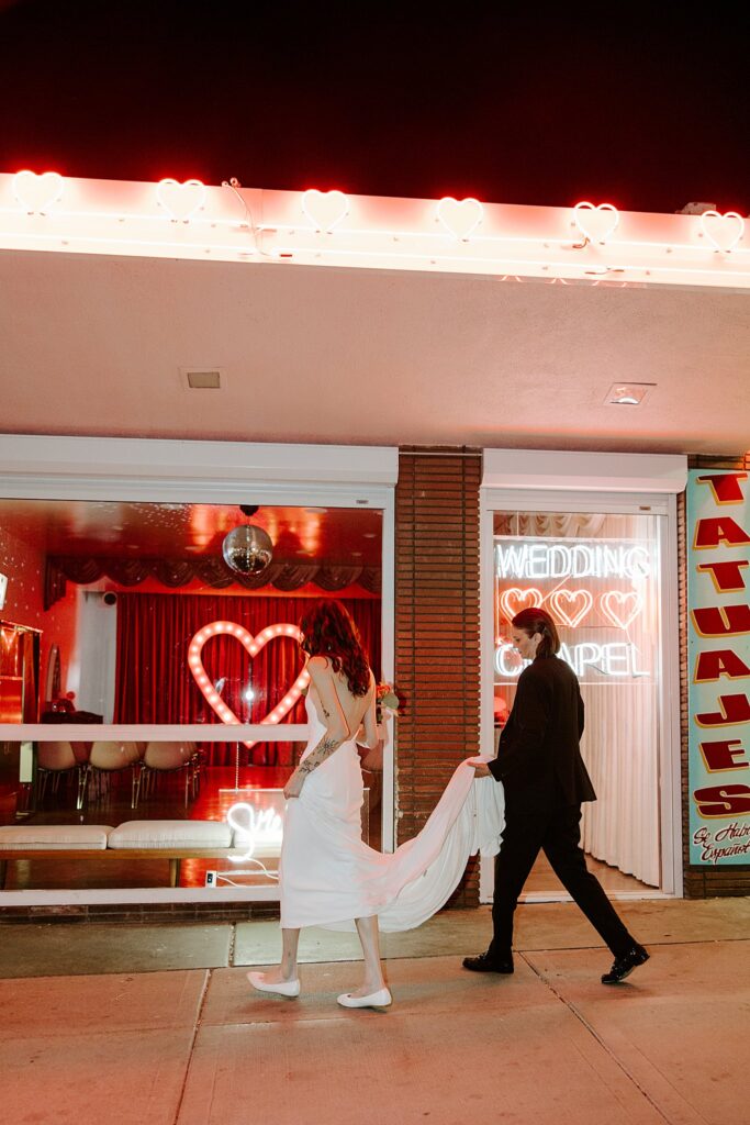 woman carries dress of her new wife by Las Vegas elopement photographer