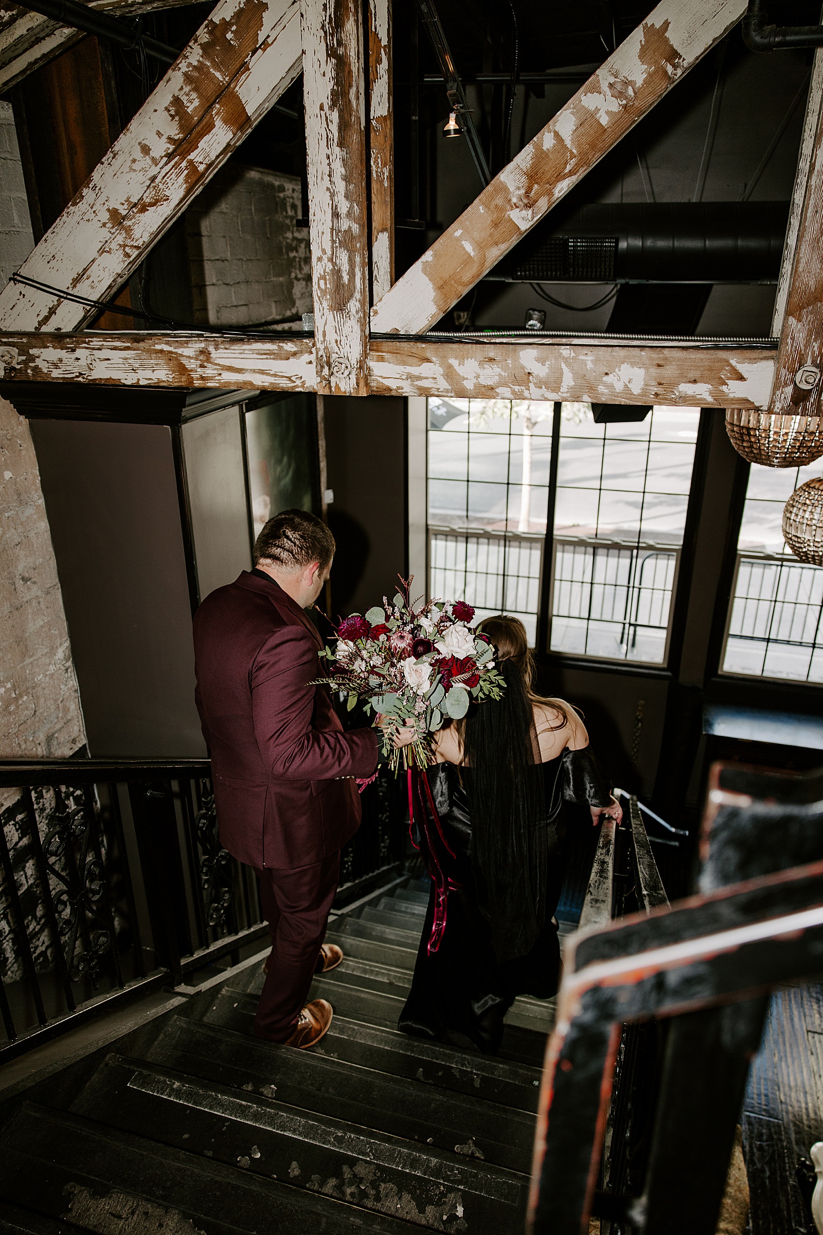 man walks down staircase with new wife after Commonwealth Ceremony