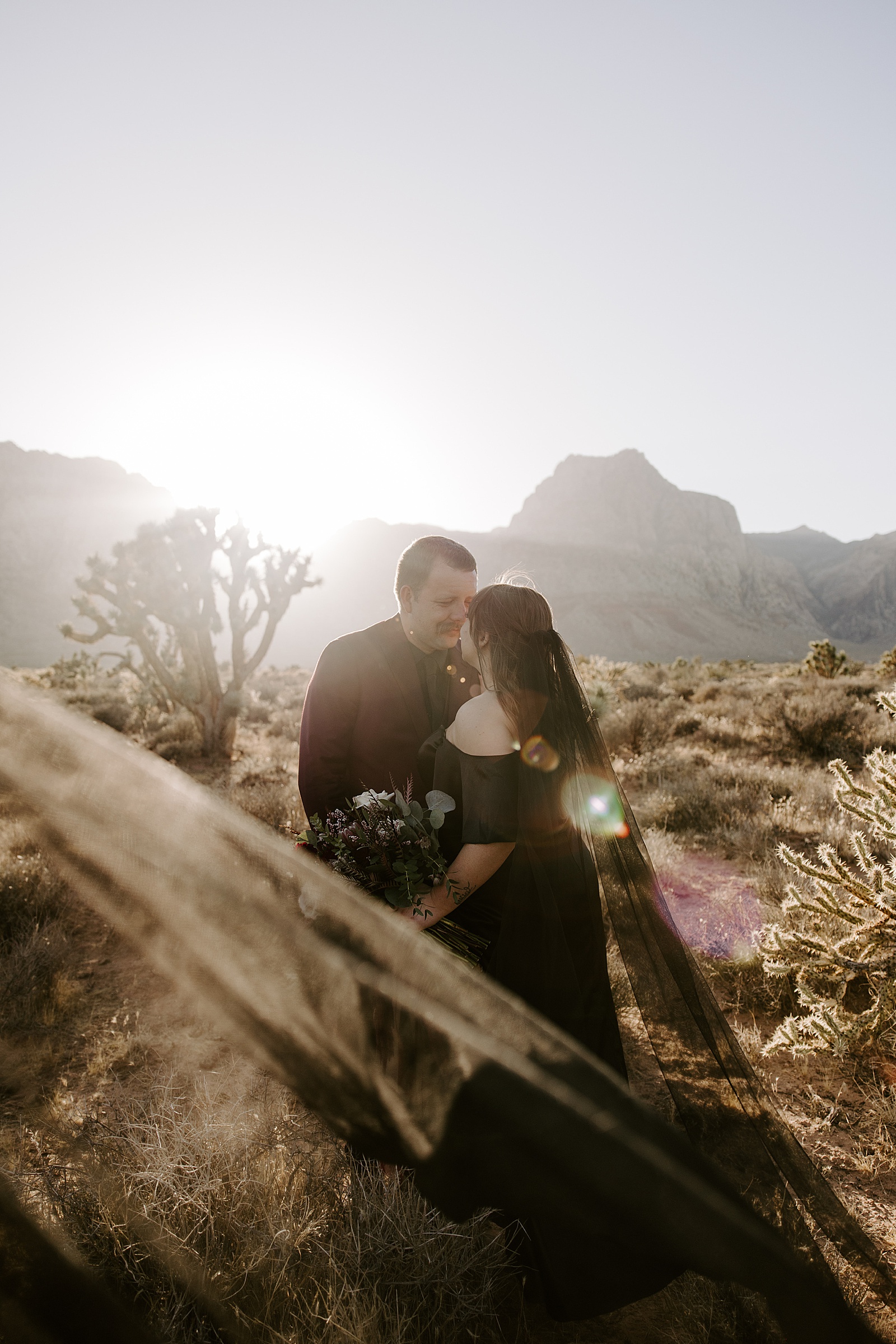 groom gazes at his new bride in the desert  by Las Vegas Elopement Photographer