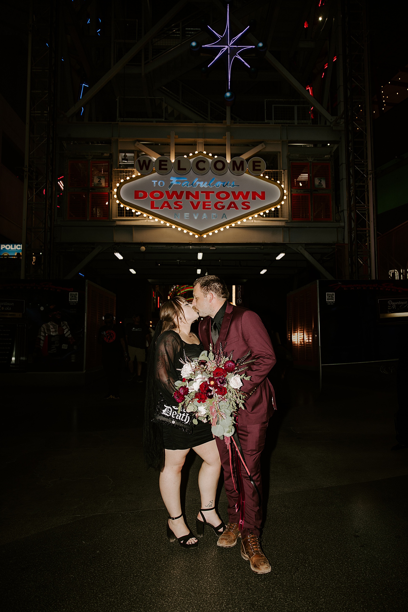 husband and wife kiss under downtown Vegas sign by Katelyn Faye Photography 