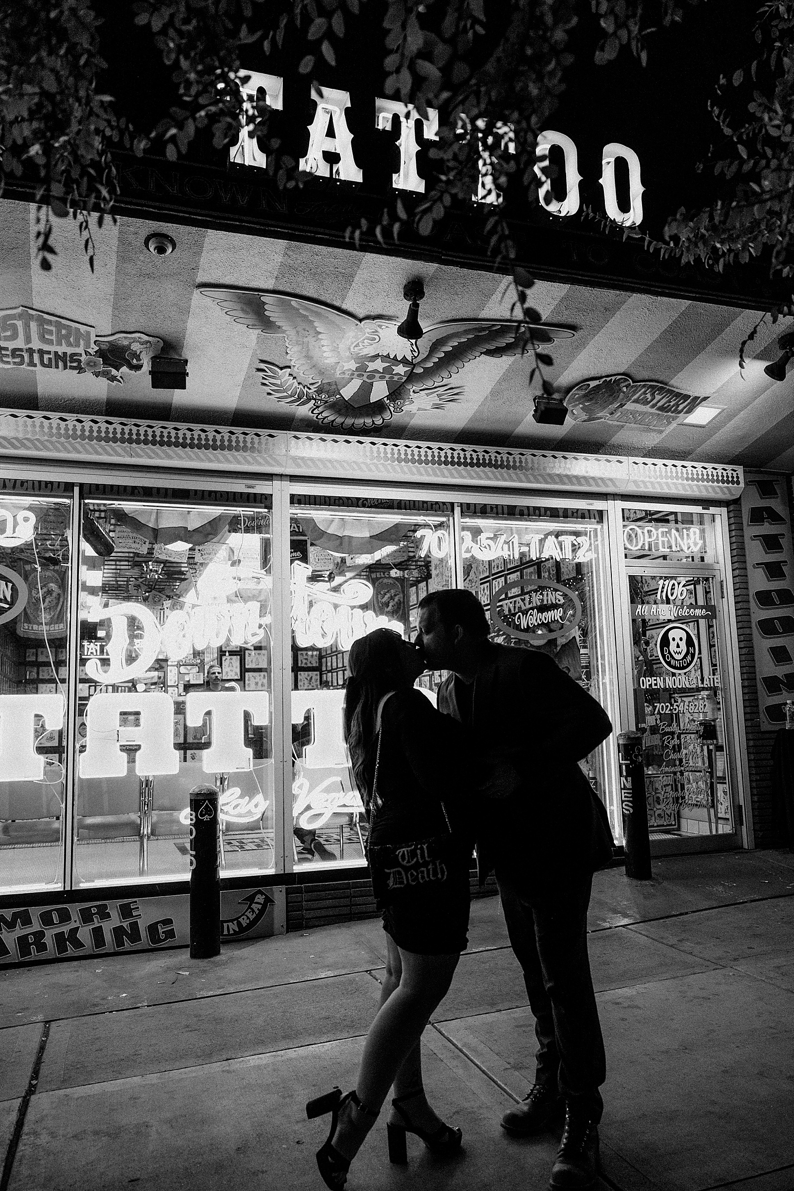 man kisses new wife under tattoo sign by Katelyn Faye Photography 