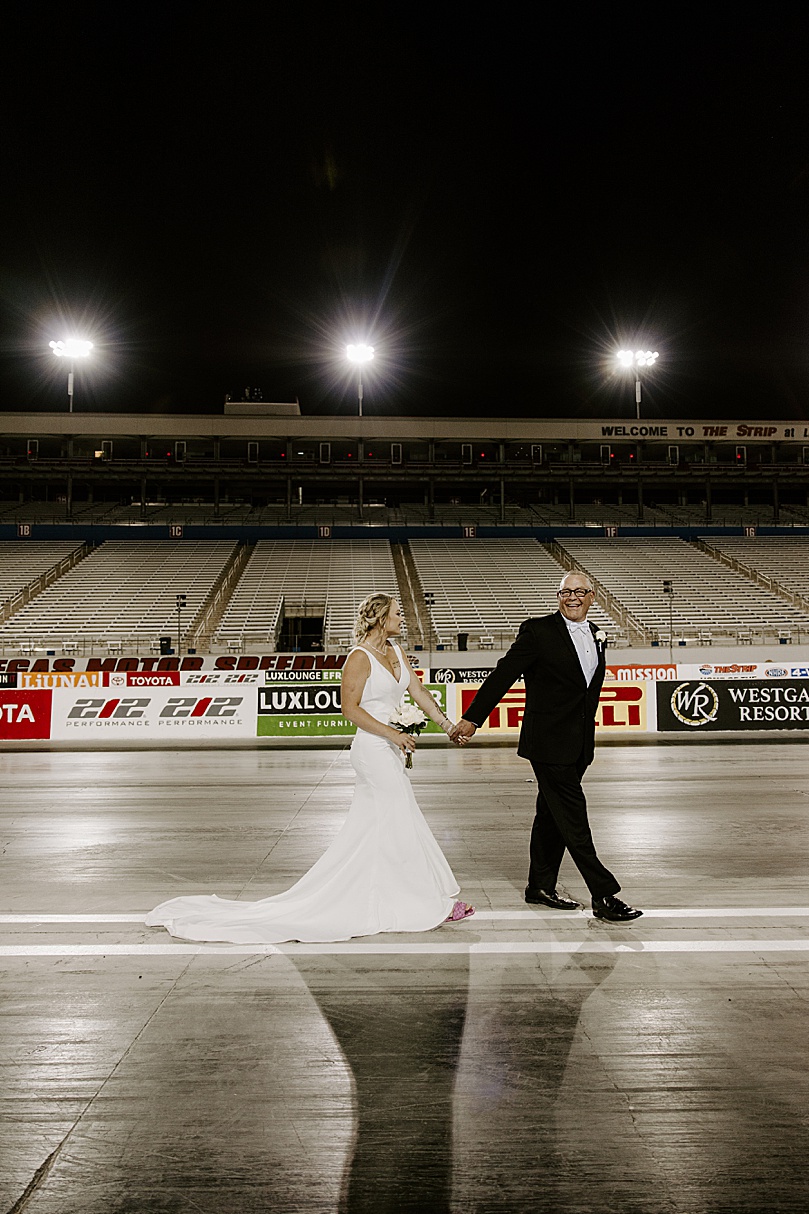 newlyweds walk on F1 Speedway by Las Vegas wedding photographer 