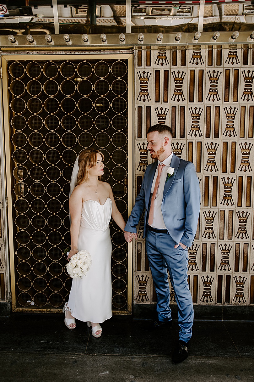 British couple leans on wall for Post-Elopement Couples Shoot