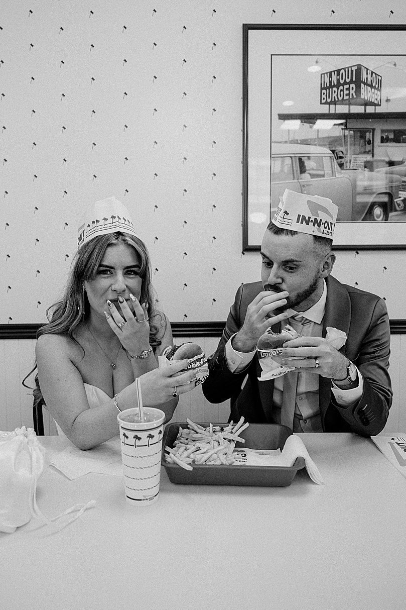 Newlyweds eat in-and-out together by Las Vegas wedding photographer