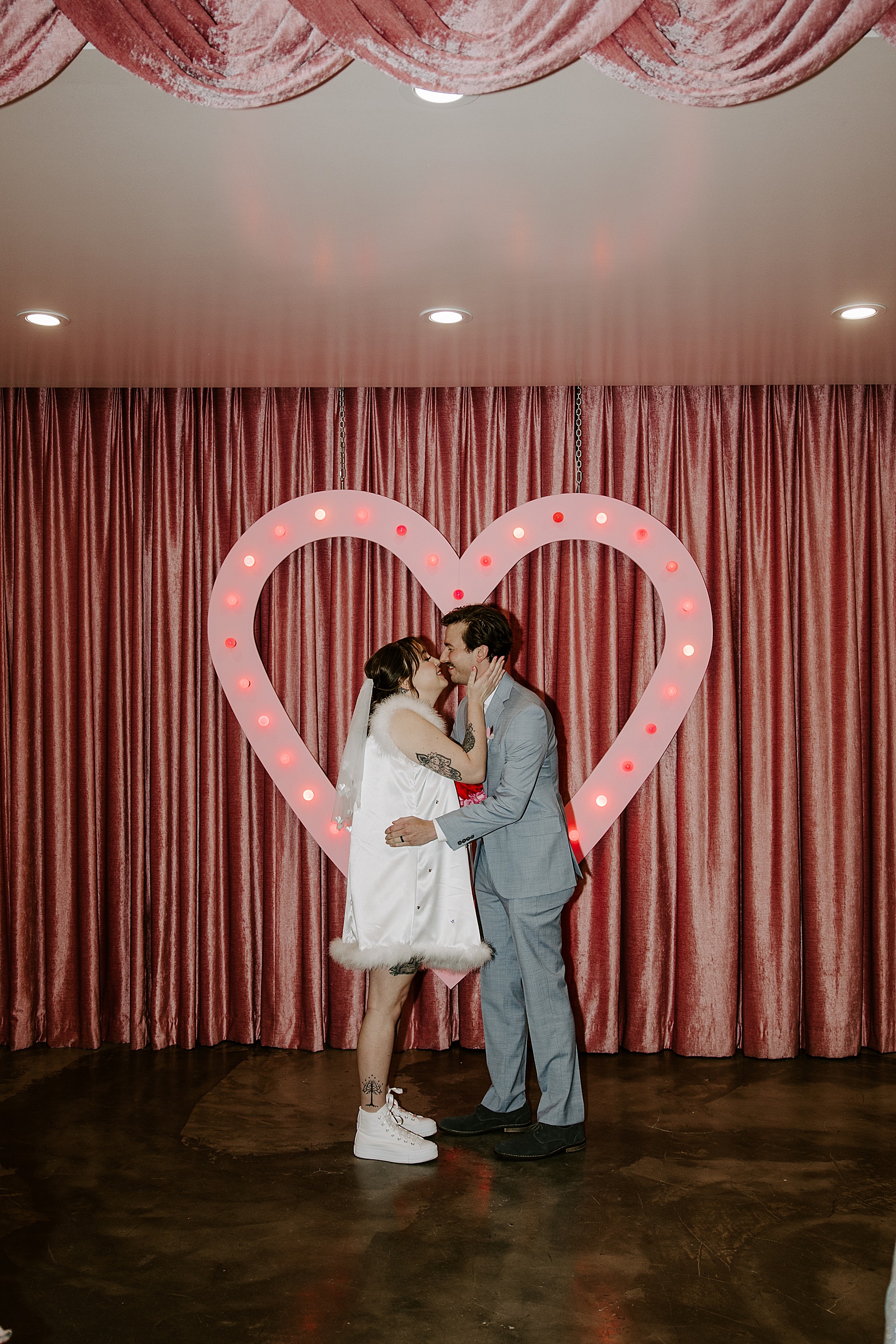 newlyweds share first kiss in front of heart shaped alter by Katelyn Faye Photo