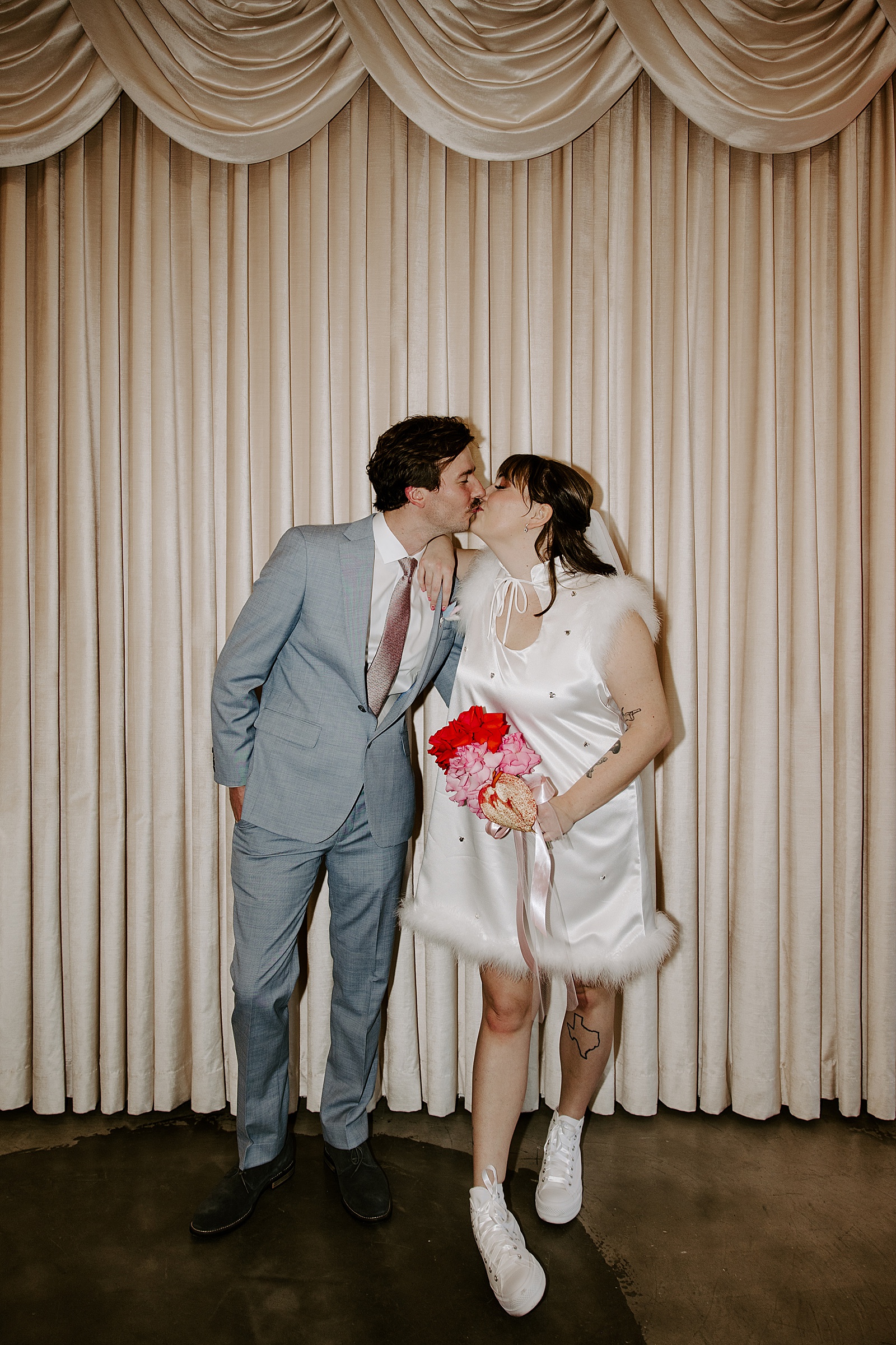 bride in sparkling mini dress kisses her man by Katelyn Faye Photo