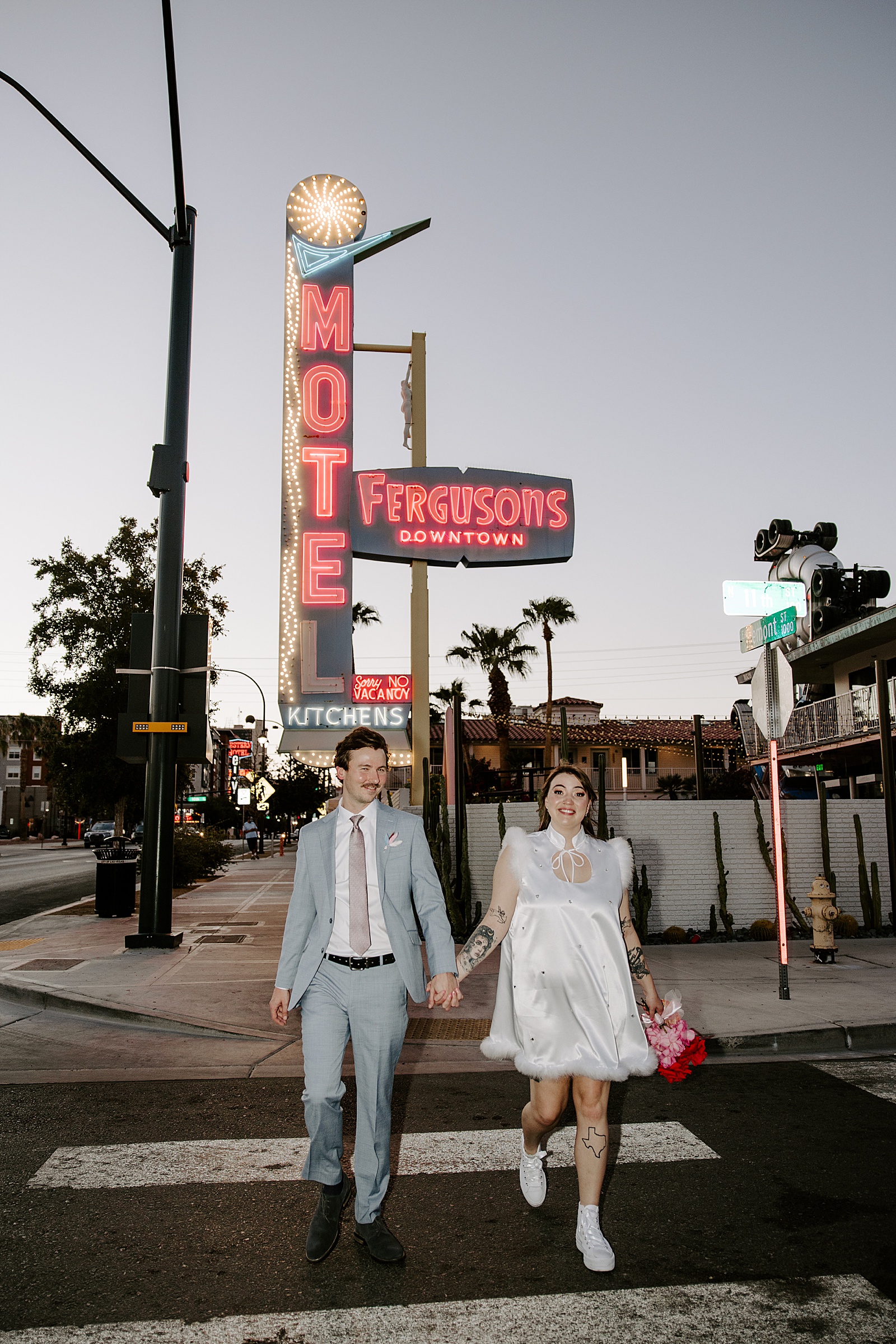 newlyweds walk across crosswalk at night by Katelyn Faye Photo