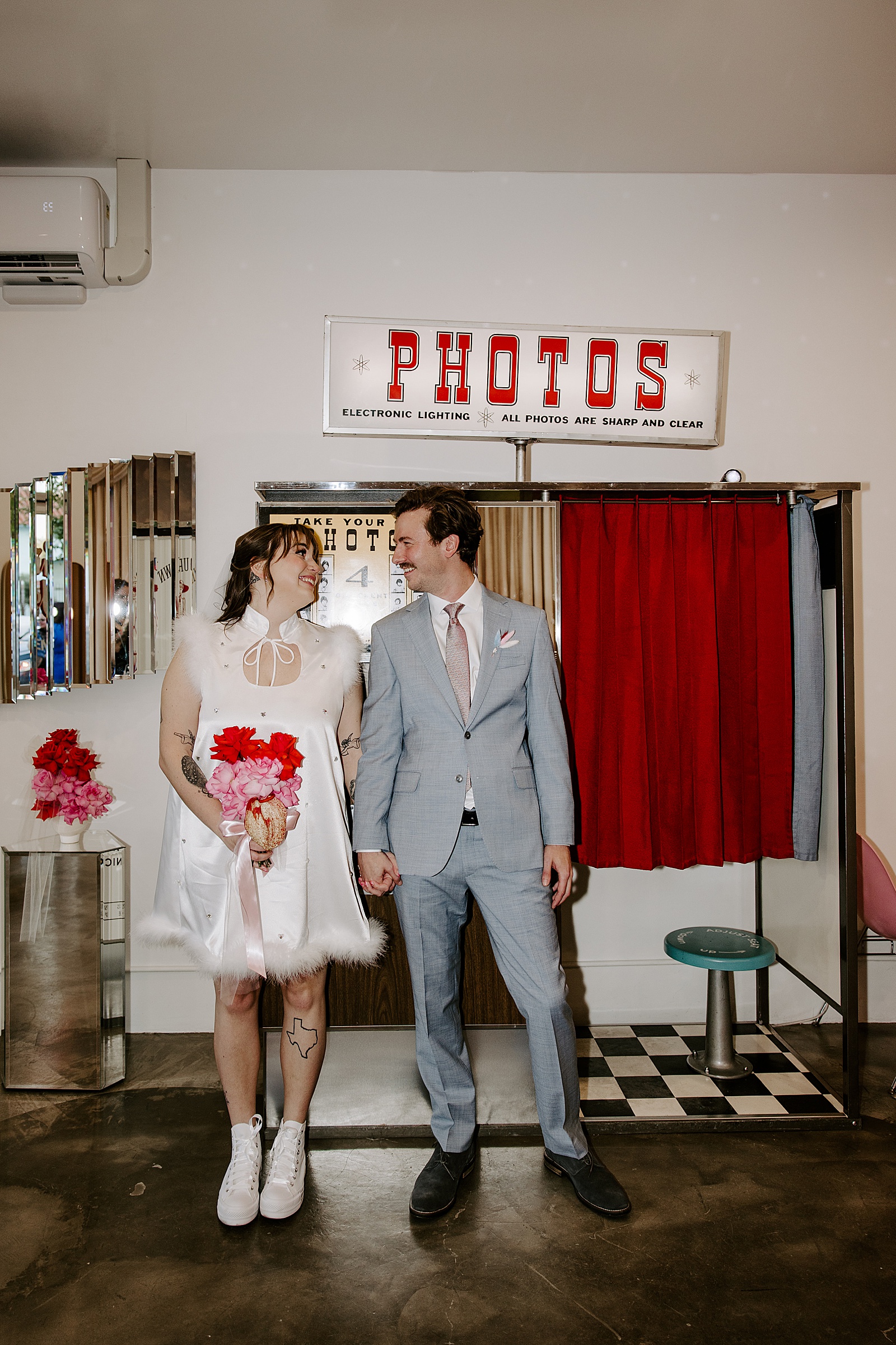 newlyweds stand in front of old Photo Booth by Las Vegas Wedding Photographer