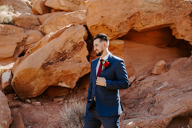 groom in navy suit in front of red rocks at Valley of Fire elopement