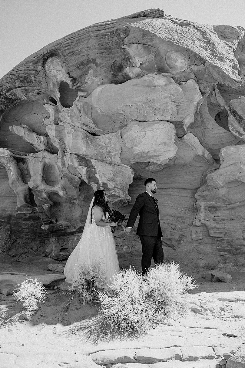 man leads new wife through desert by Las Vegas Elopement Photographer