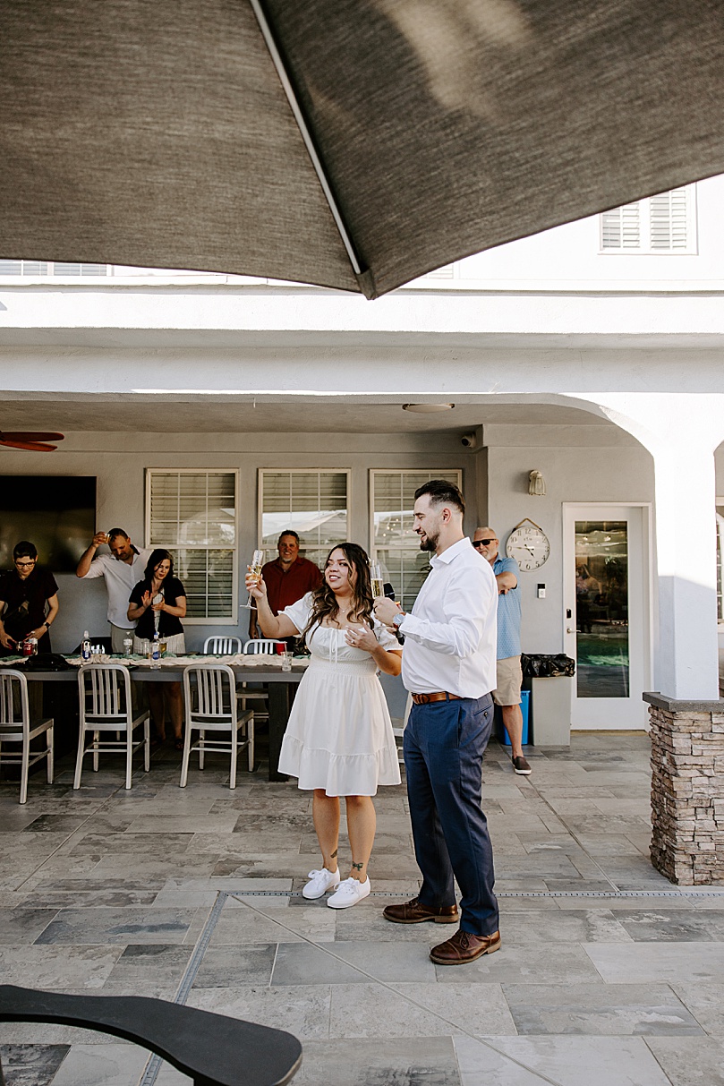 newlyweds raise a toast at backyard reception by Katelyn Faye Photo