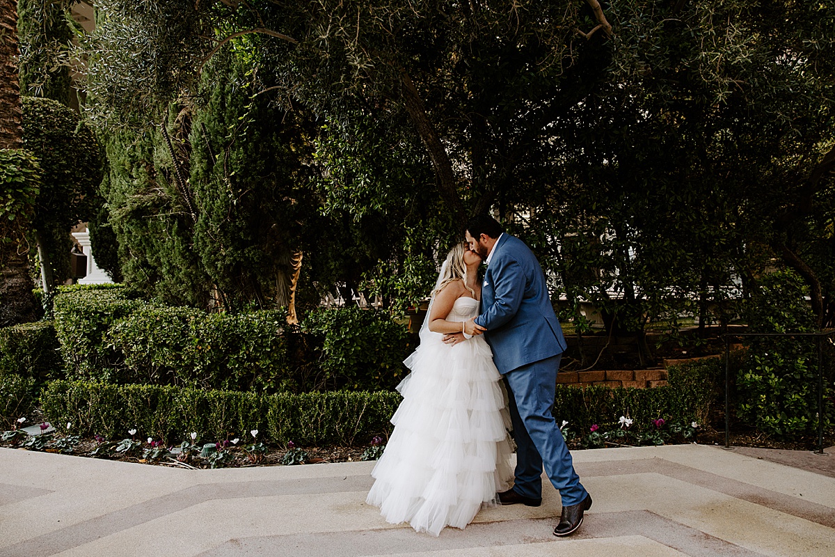 Couple shares a kiss in wedding attire by Katelyn Faye Photography