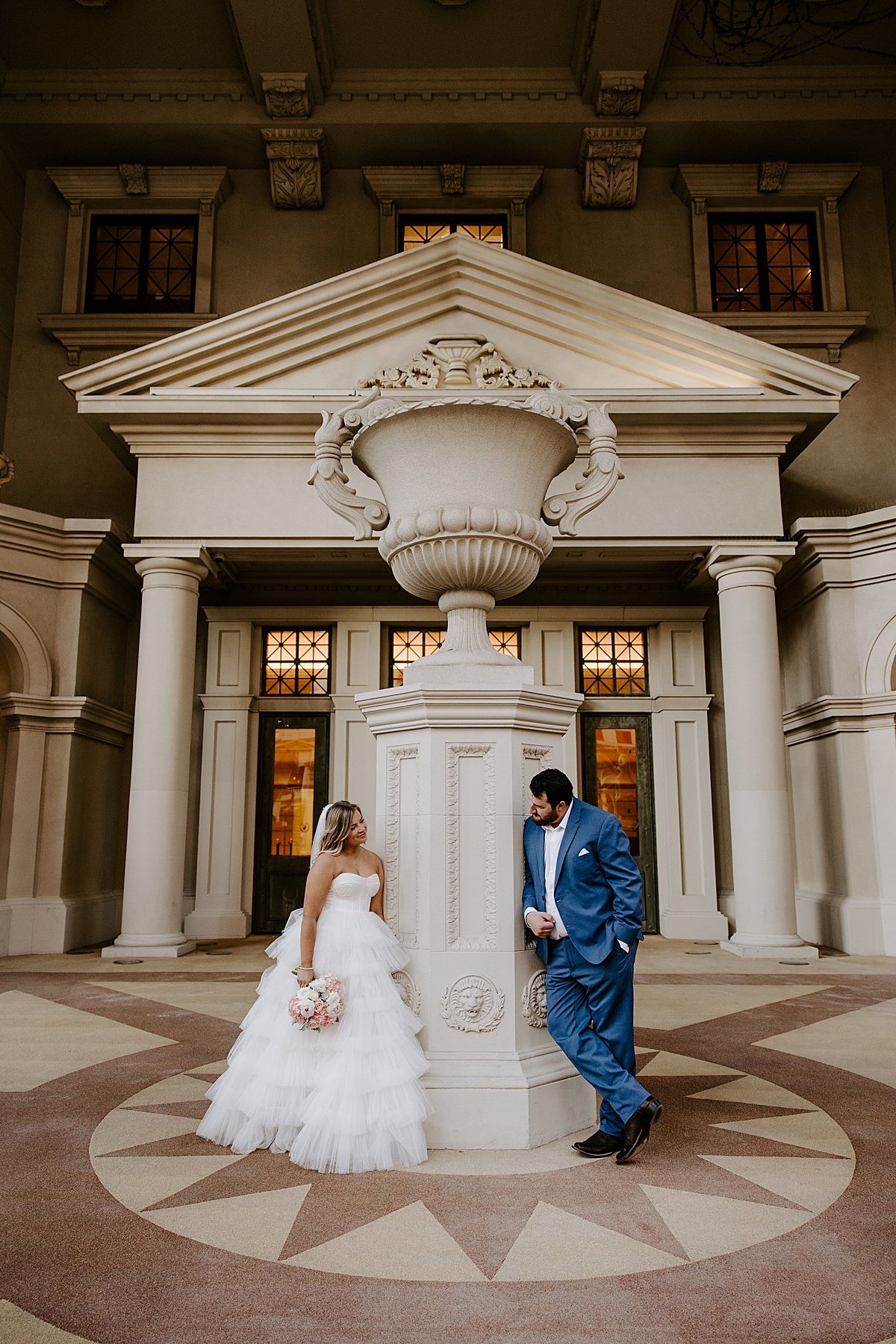 Groom peers over column at bride by Las Vegas Wedding Photographer