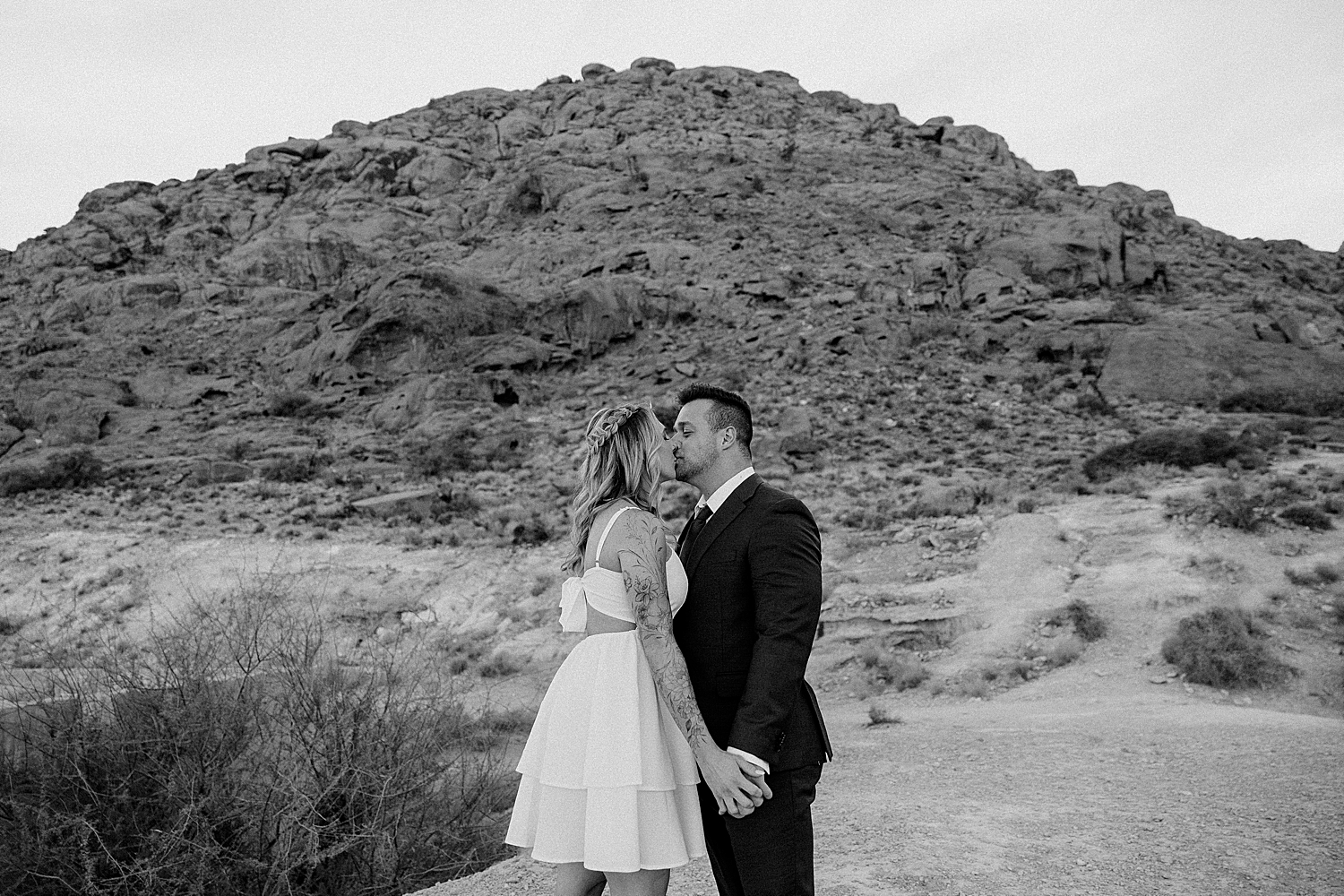 man and woman kiss near red rocks for Canyon Engagement Session