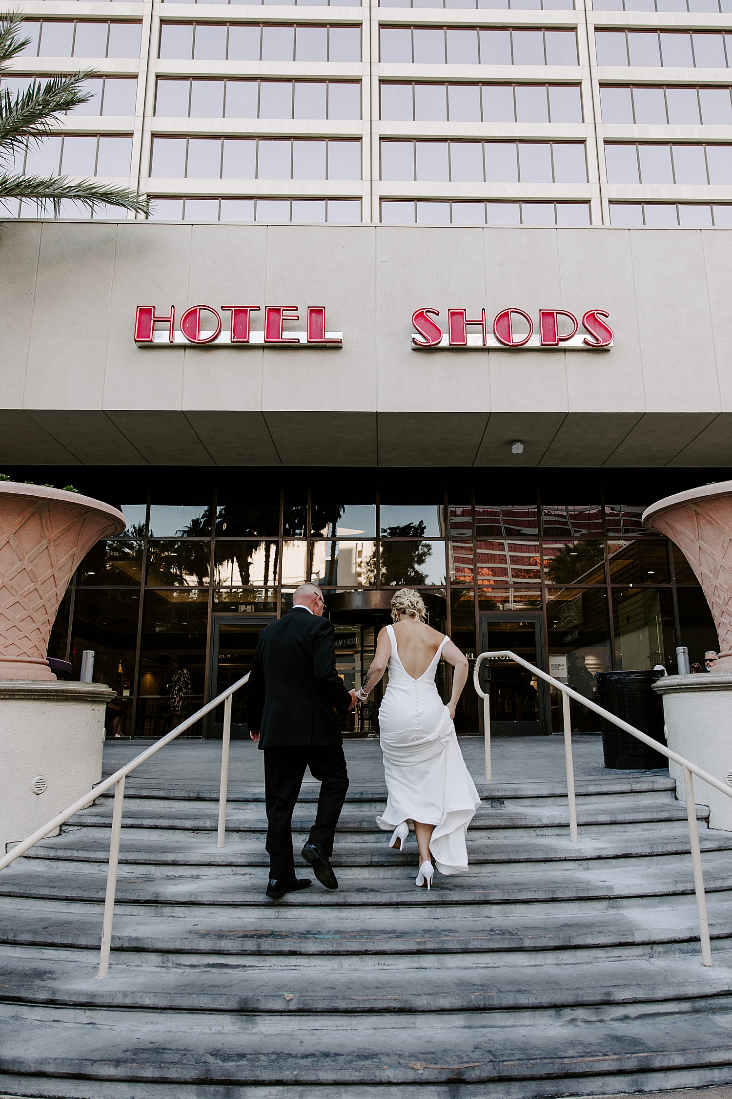 woman in Classic wedding gown climbs hotel steps by Katelyn Faye Photo