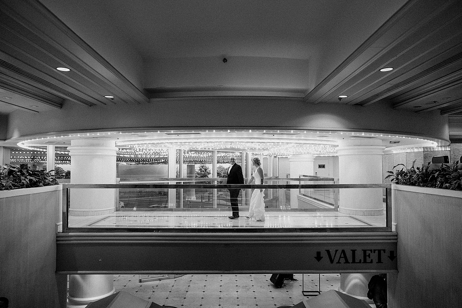 couple walk across walkway in hotel by Las Vegas Wedding Photographer