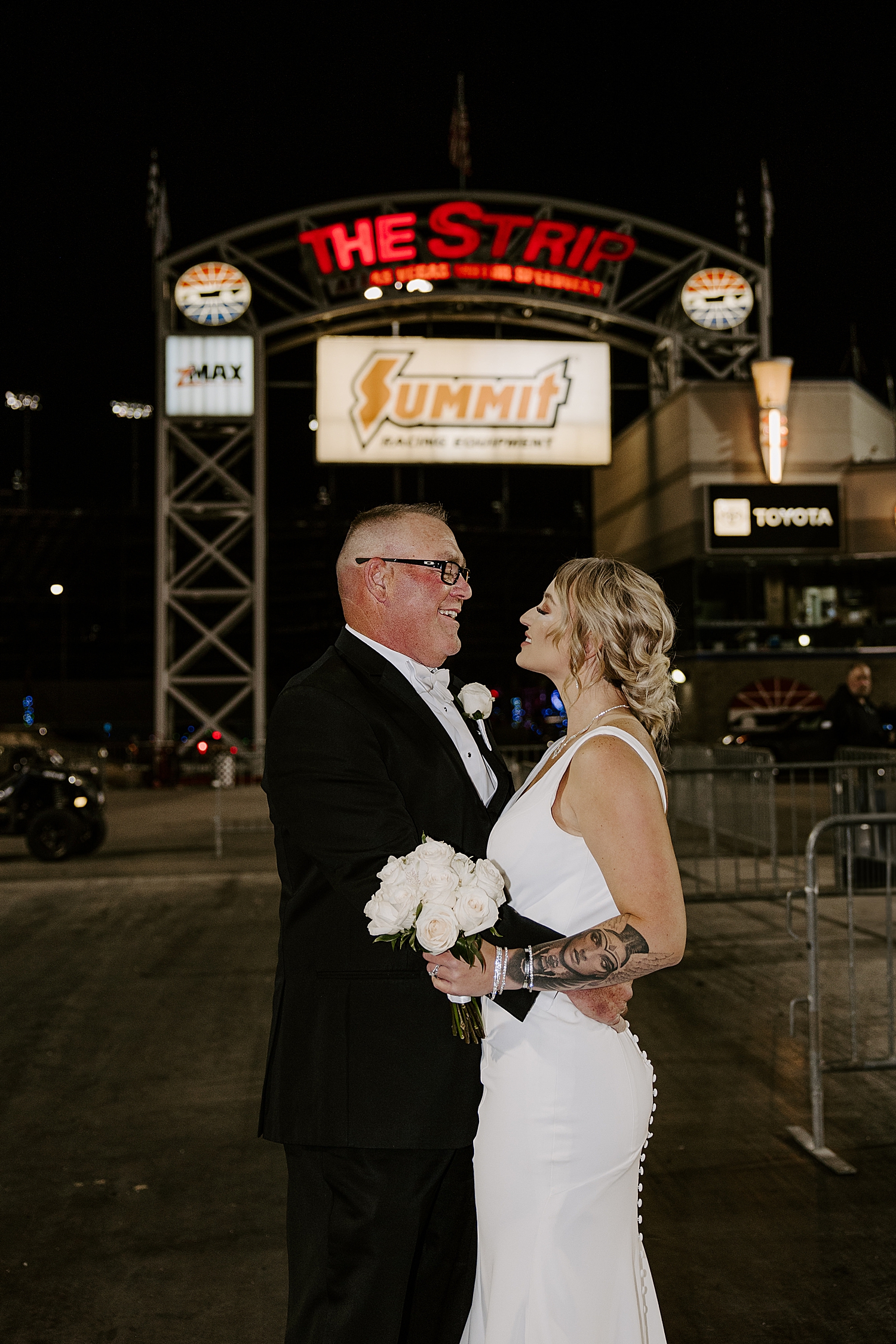 newlyweds kiss under sign at Speedway Pitstop