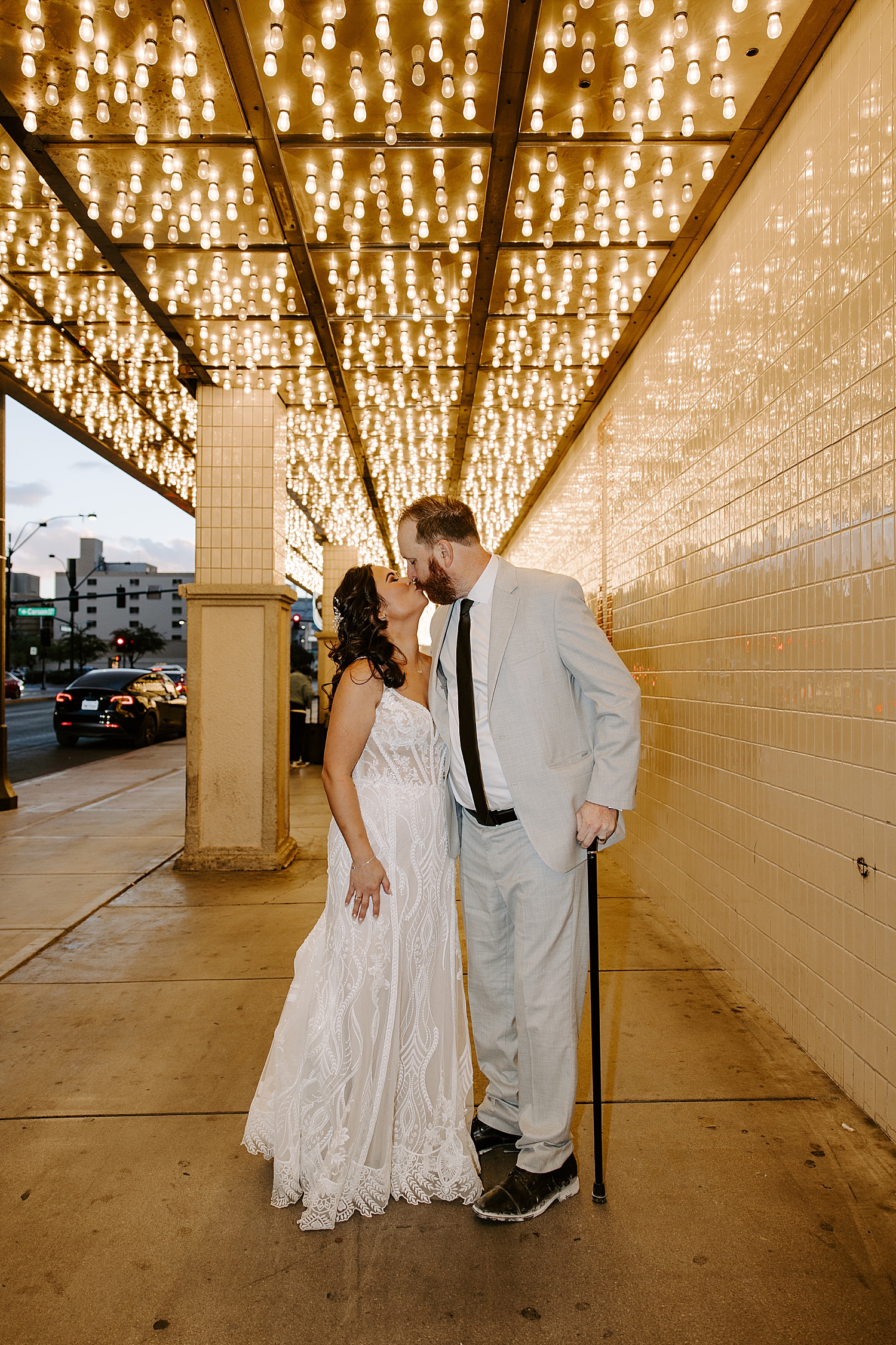 man and woman kiss under lights on Fremont street by Las Vegas wedding photographer 