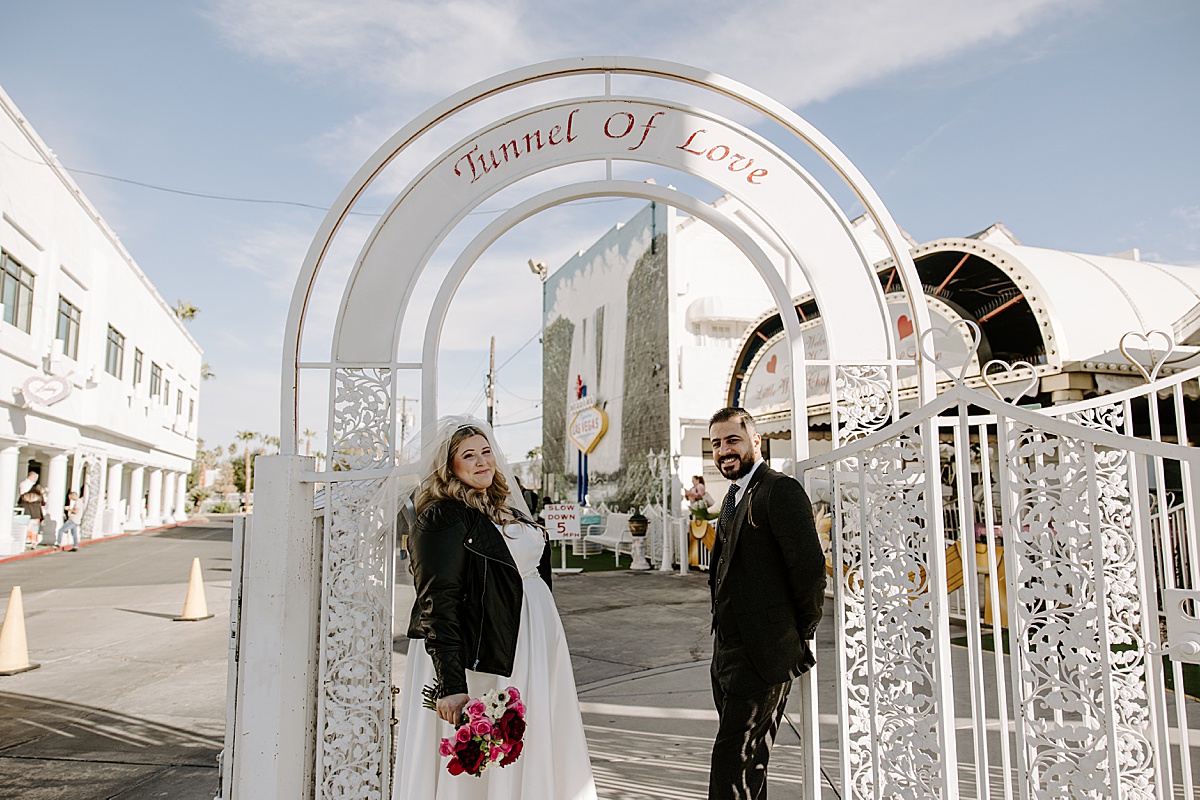 couple standing under gate wondering What to Do with Your wedding Photos