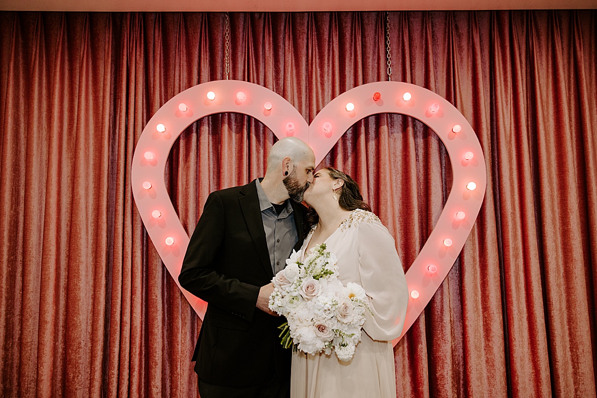 edgy couple shares a kiss at intimate chapel elopement