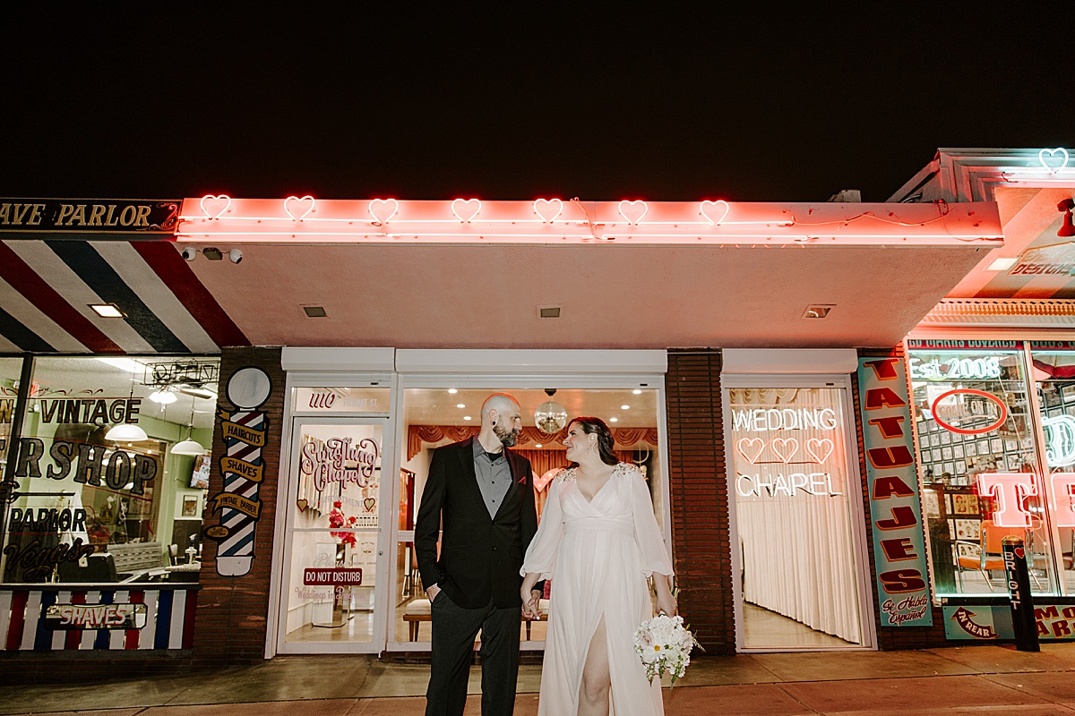 bride and groom posing under neon lights by katelyn faye photography