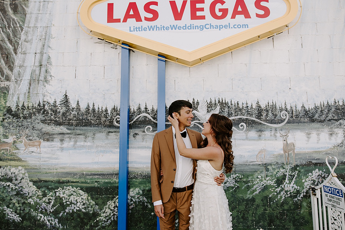 bride in white dress admiring her groom by las vegas wedding photographer